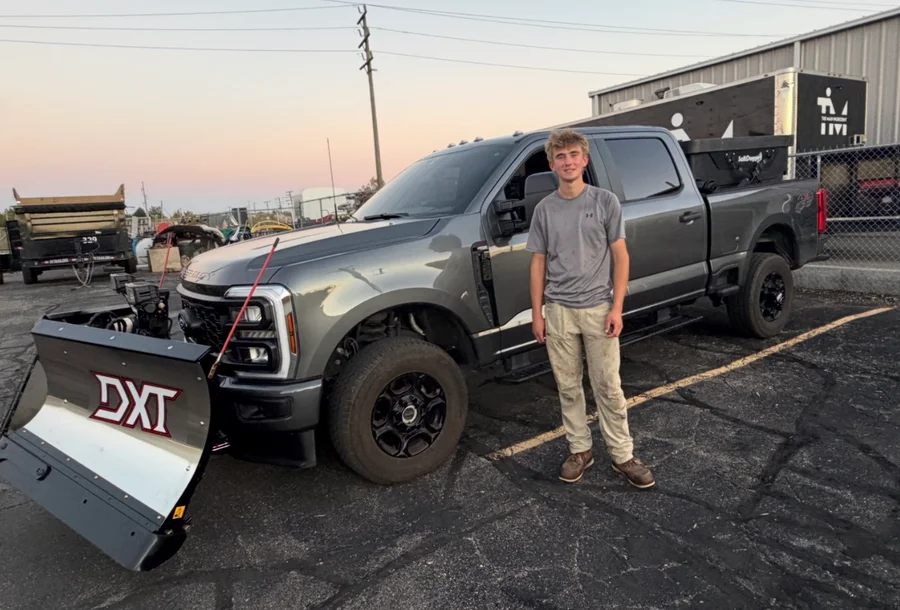 DR team member beside the work truck and equipment trailer